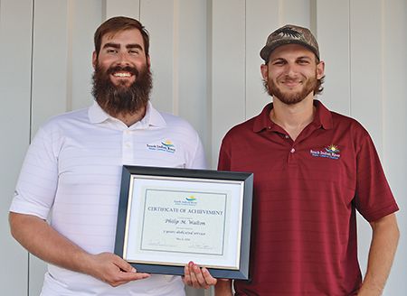 Supervisor of Operations Dustin Fazio on right, presents Philip Walton with a certificate for five years of service